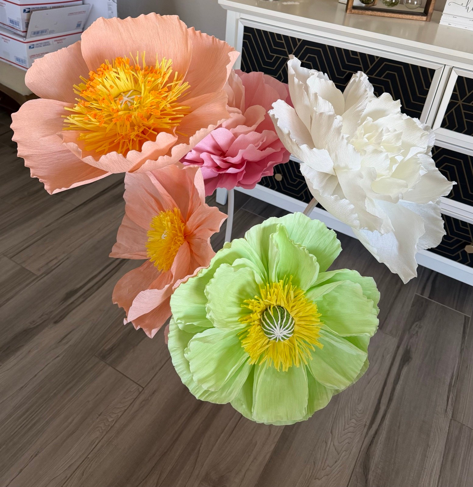 A bouquet of giant paper flowers in peach, pink, white and pale green